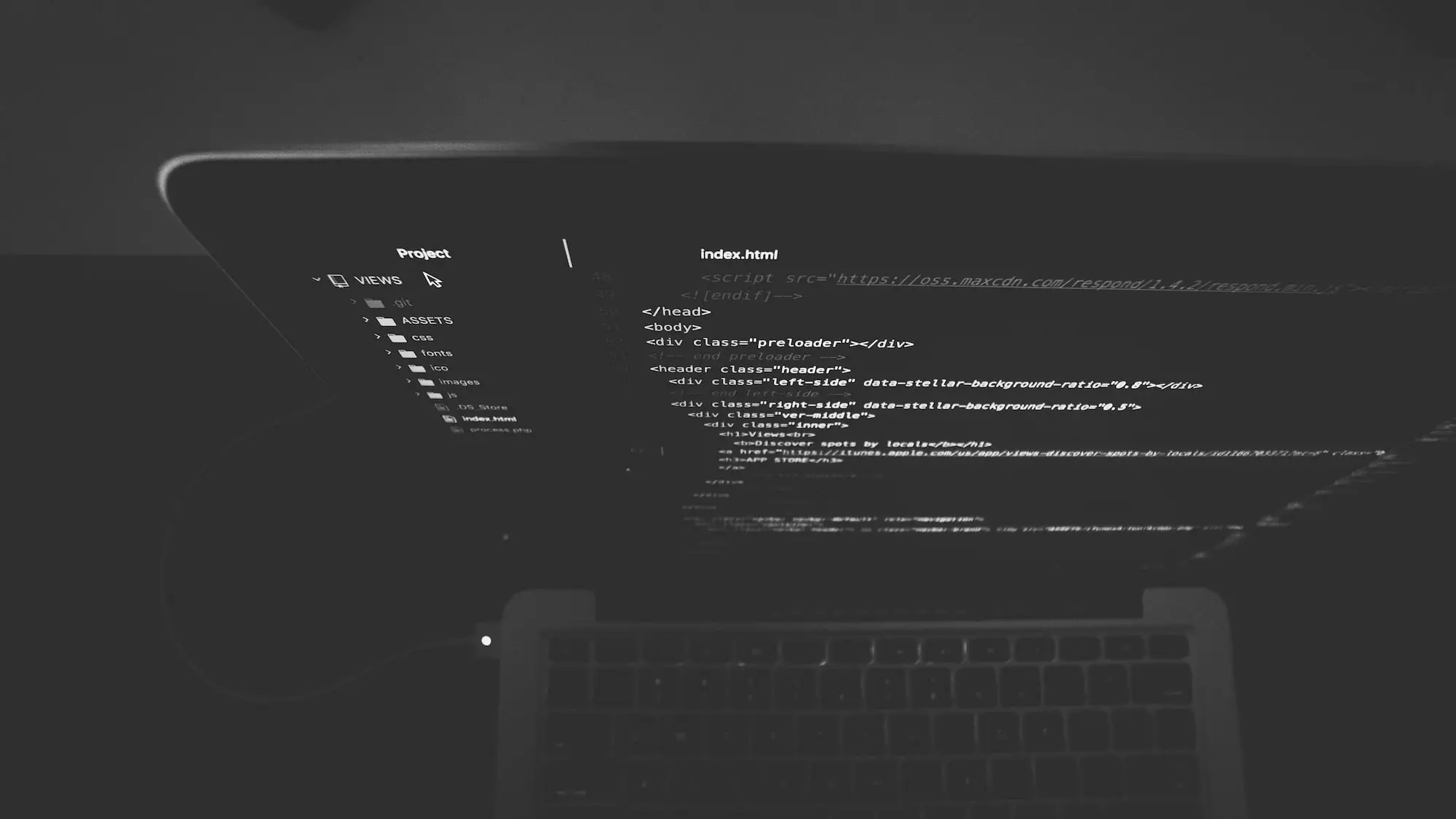 Black and white picture of a macbook showing code on the right and a folder with projects on the left
