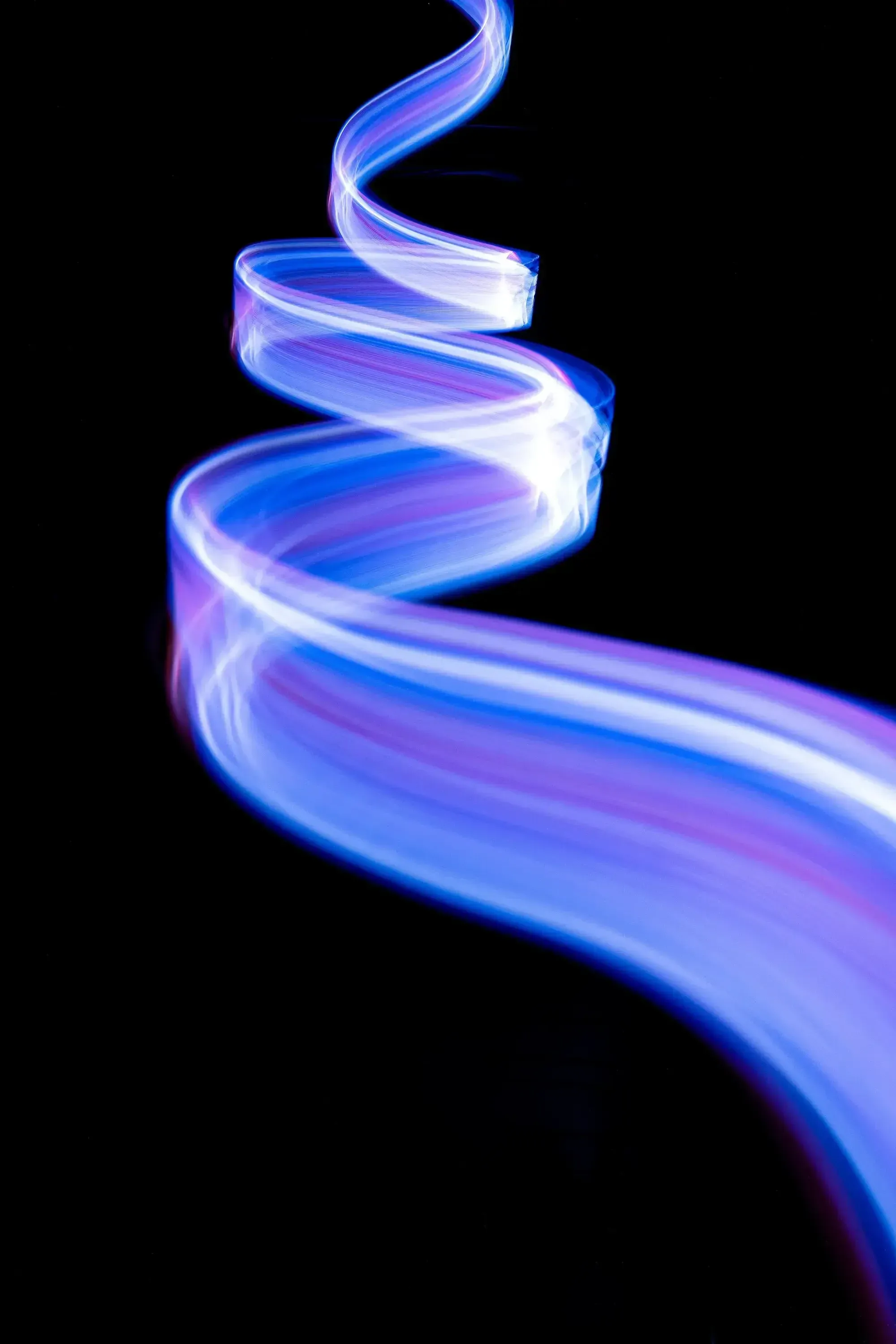 Blau-lila Lichtstreifen in einer Spirale auf schwarzem Hintergrund.